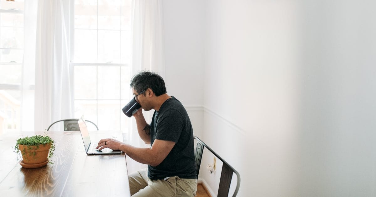 Hybrid Work Man sitting at home drinking coffee in work from home office