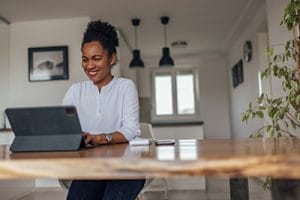 Casually dressed woman, working from home, over the digital tablet.