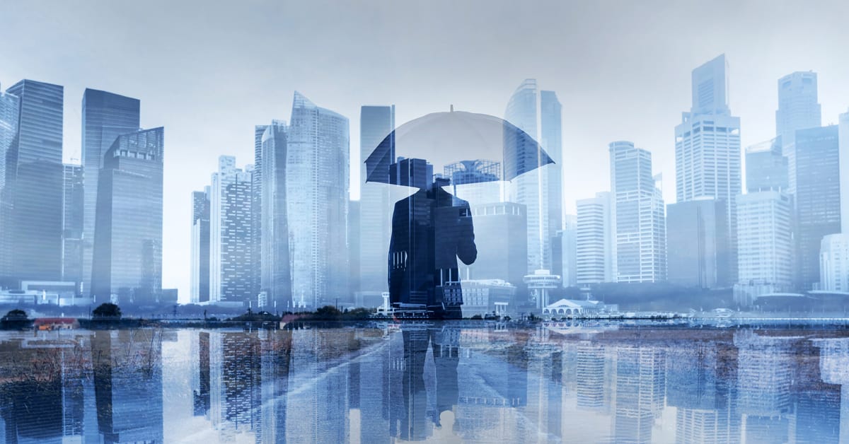man under umbrella in front of city skyline