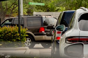 Cars waiting in a drive thru lane. Sports utility vehicles in America.