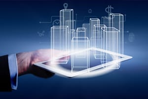 Hand of businessman in suit holding tablet with computer generated buildings