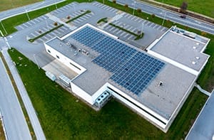 Drone shot of commercial real estate eco-friendly sustainable building with solar panels on the roof and new HVAC system