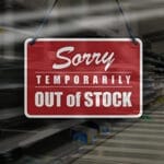 Business concept of empty store shelves with 'Sorry, Temporarily Out of Stock' sign.