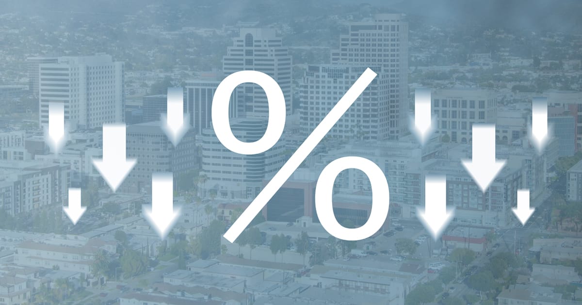 percent symbol surrounded by down arrows on a faded blue background of the Los Angeles skyline