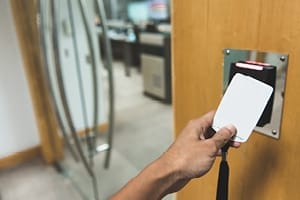 person swiping a security card to enter office space